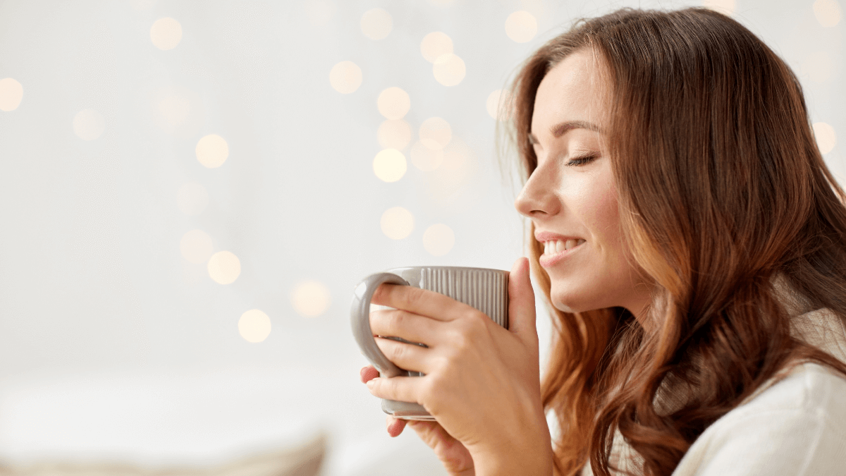 Joyful woman savoring a moment of solitude with a cup of coffee, embodying the art of living alone.